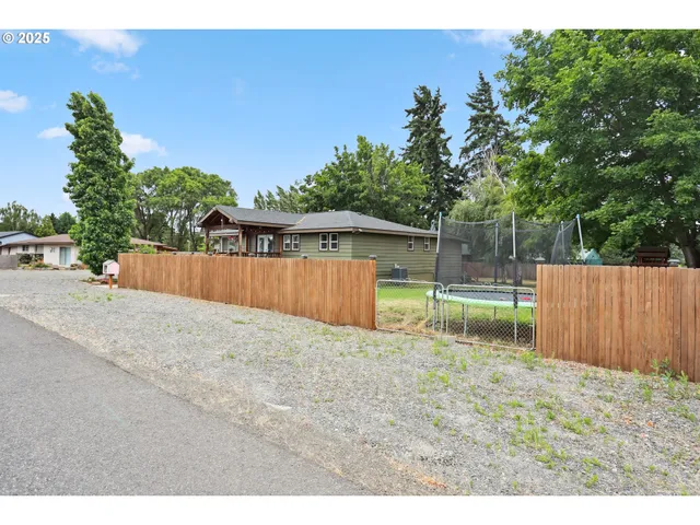 a backyard of a house with a yard and wooden fence