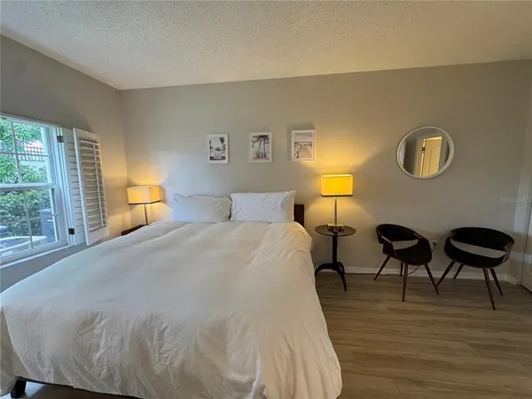 a bedroom with a bed and a lamp next to a window