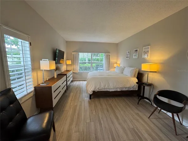 a bedroom with a bed and wooden floor