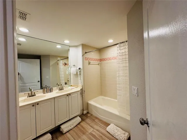 a bathroom with a double vanity sink mirror and shower