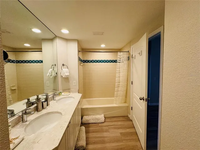 a bathroom with a tub shower vanity and a sink
