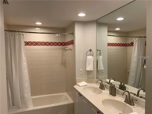 a bathroom with a mirror a sink and a shower