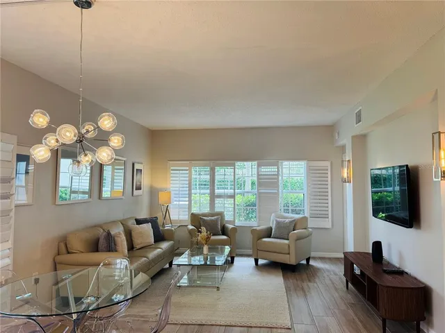 a living room with furniture a flat screen tv and a large window