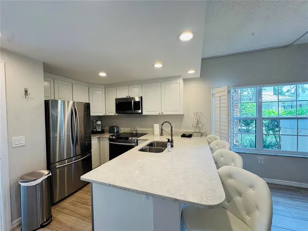 a kitchen with stainless steel appliances wooden floor dining table and chairs