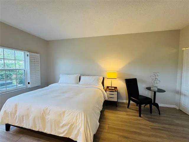 a bedroom with a bed a table and chair