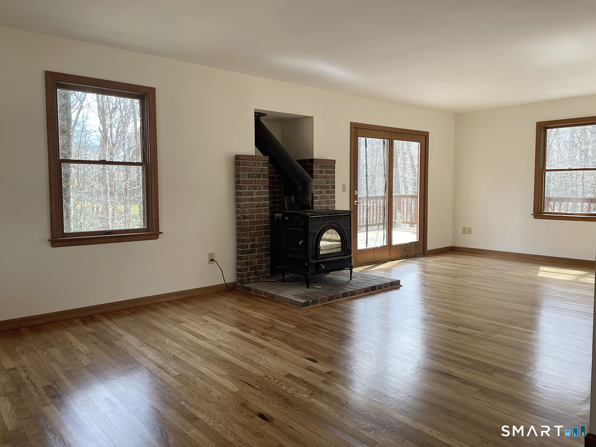 1315 Purchase Brook Road Southbury, CT 06488 - Photo 6 of 41 a view of an empty room with wooden floor and a window