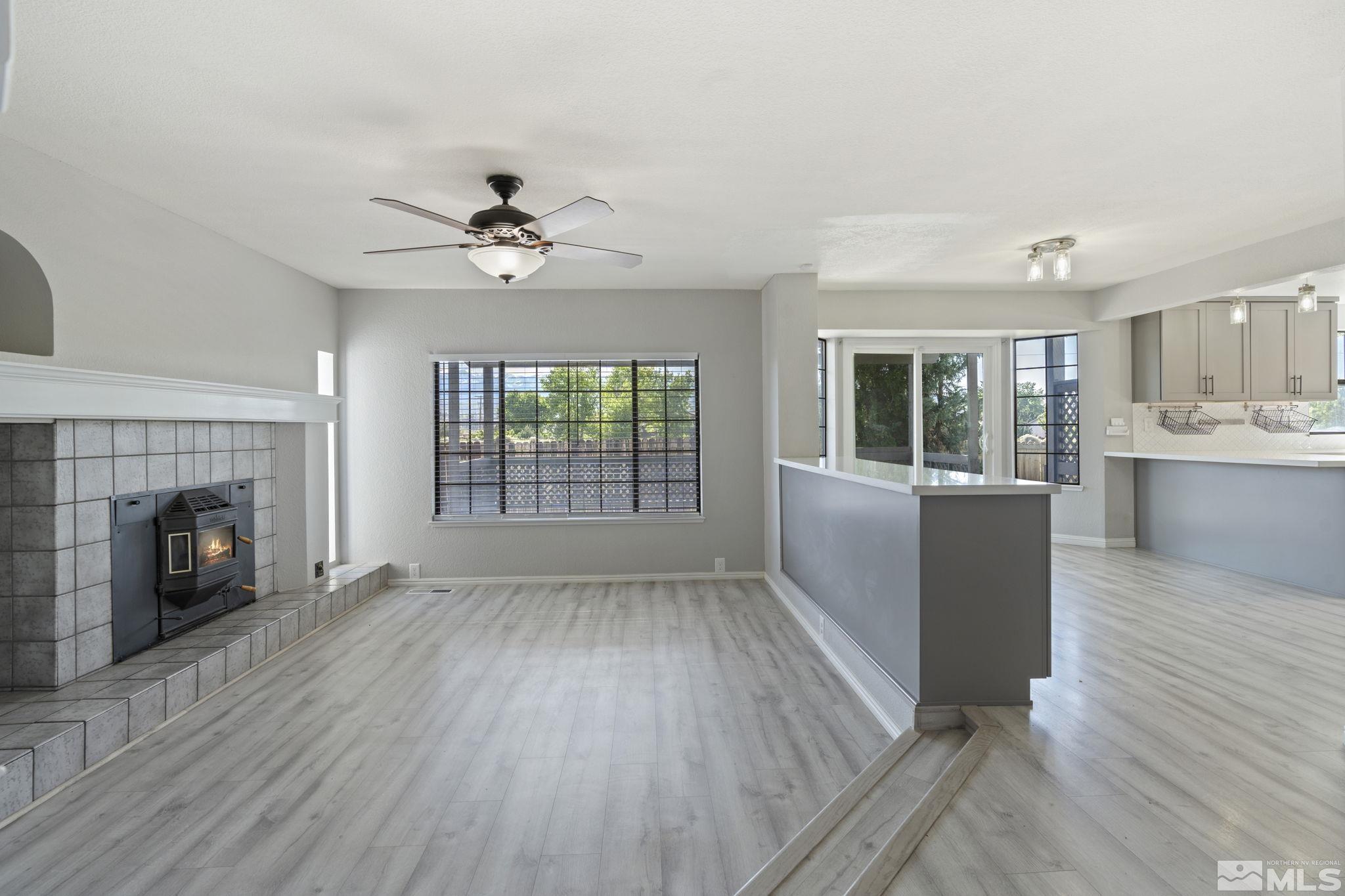 14050 Riata Circle Reno, NV 89521 - Photo 11 of 33 an empty room with fireplace wooden floor and windows