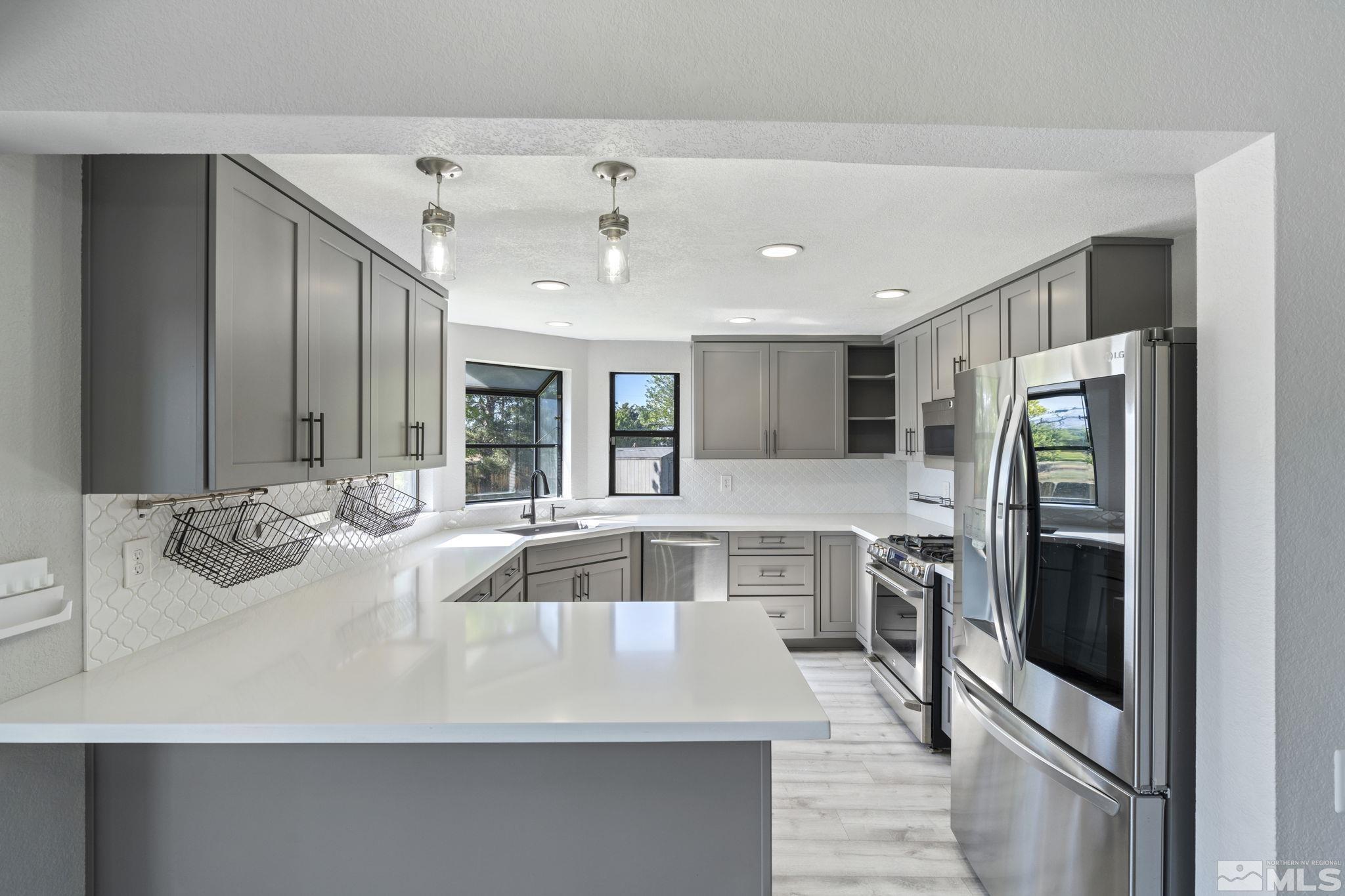 14050 Riata Circle Reno, NV 89521 - Photo 5 of 33 a large kitchen with a large counter top stainless steel appliances and cabinets