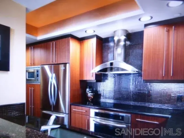a kitchen with stainless steel appliances granite countertop a refrigerator and a stove