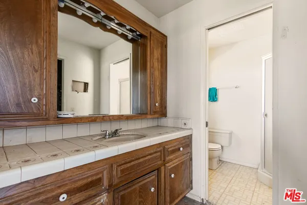 a bathroom with a granite countertop sink toilet and shower