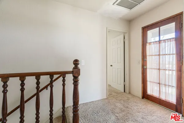 a view of a hallway with wooden floor and entryway