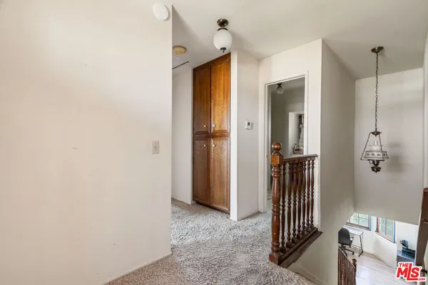 a view of a hallway with a door and stairs