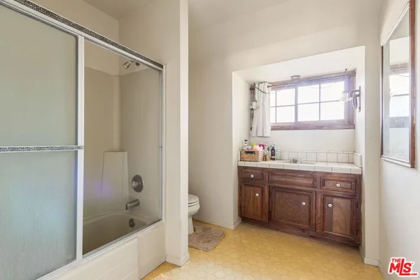 a bathroom with a tub sink shower and mirror