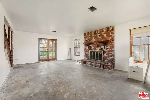 a view of an empty room with a fireplace and a window