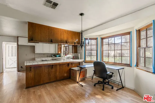 a view of a workspace with furniture and a window