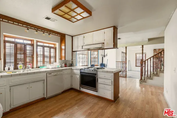 a kitchen with stainless steel appliances granite countertop a stove and wooden floor