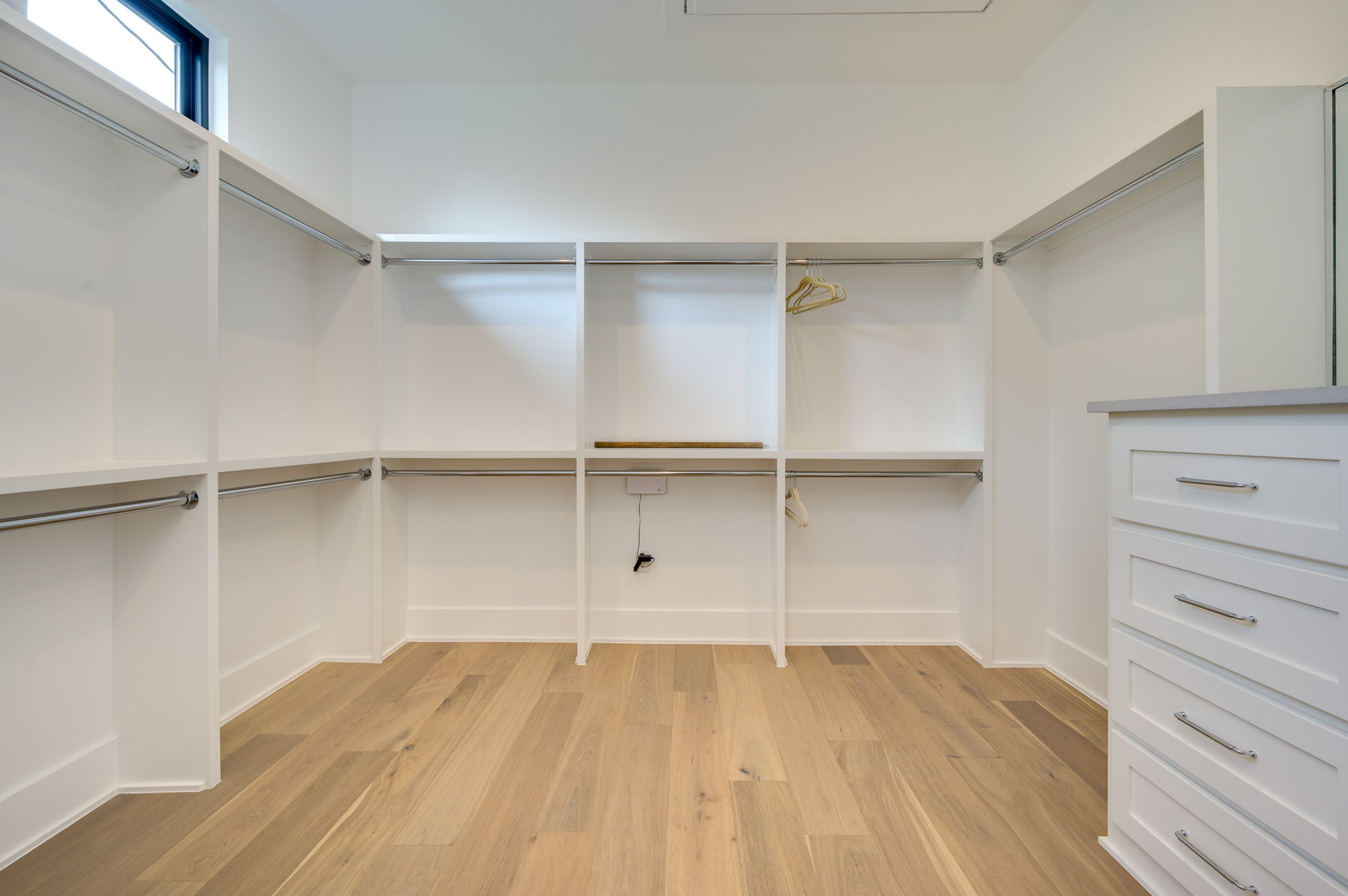 2415 McCall Road Austin, TX 78703 - Photo 29 of 40 Ample storage solutions and warm wood flooring define this bright, functional walk-in closet space.