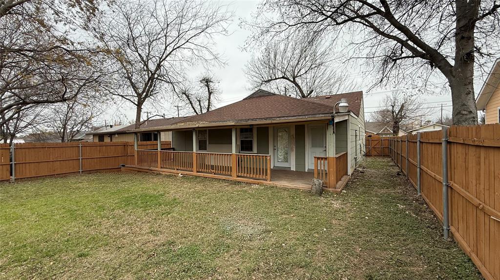 2246 Anson Road Dallas, TX 75235 - Photo 18 of 20 Expansive backyard featuring a manicured lawn, full wood fencing, and a covered wood deck