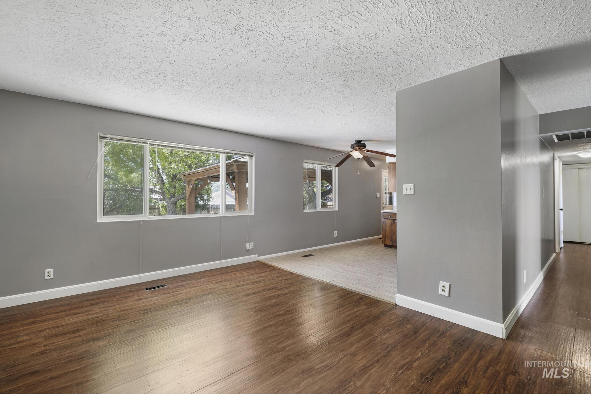 712 Locust Street Kimberly, ID 83341 - Photo 5 of 26 Expansive backyard featuring a large mature tree providing natural shade, a manicured lawn, and a concrete patio with a wooden pergola