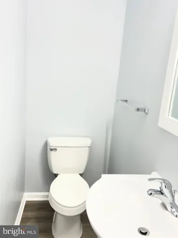 a white toilet sitting next to a white sink