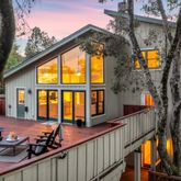 a view of a house with large windows and a small yard