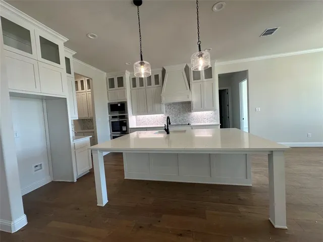 a kitchen with stainless steel appliances granite countertop a sink a stove and a wooden floors