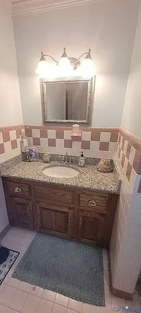 a bathroom with a granite countertop sink mirror vanity and toilet