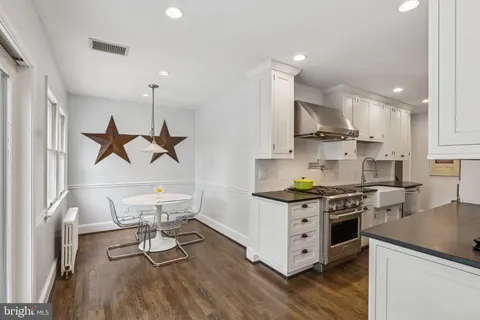 a kitchen with stainless steel appliances a stove a sink a refrigerator and wooden floor