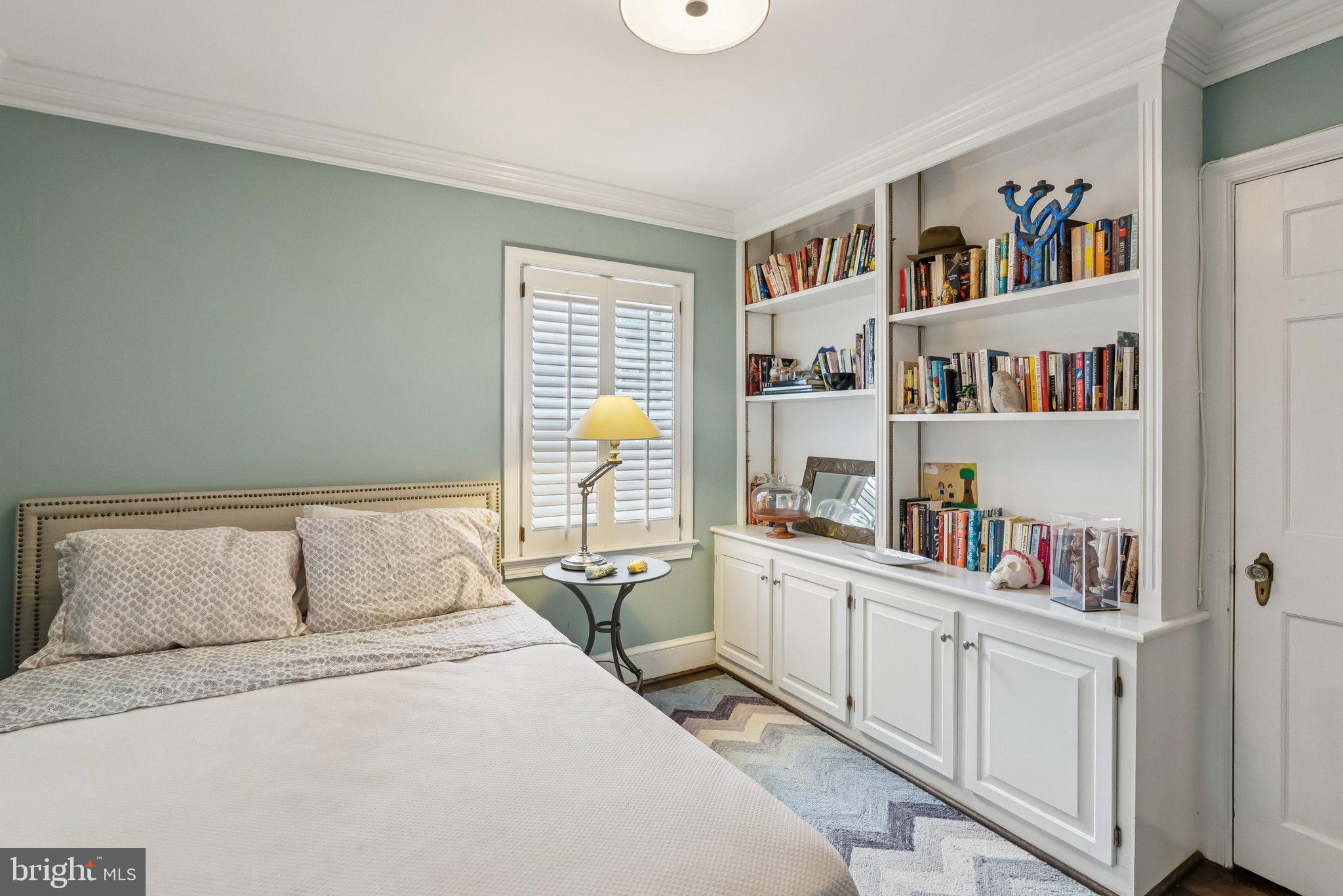 8109 Custer Road Bethesda, MD 20814 - Photo 19 of 54 a bedroom with a bed a book shelf and a book shelf
