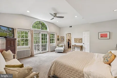 a spacious bedroom with a bed and a large window