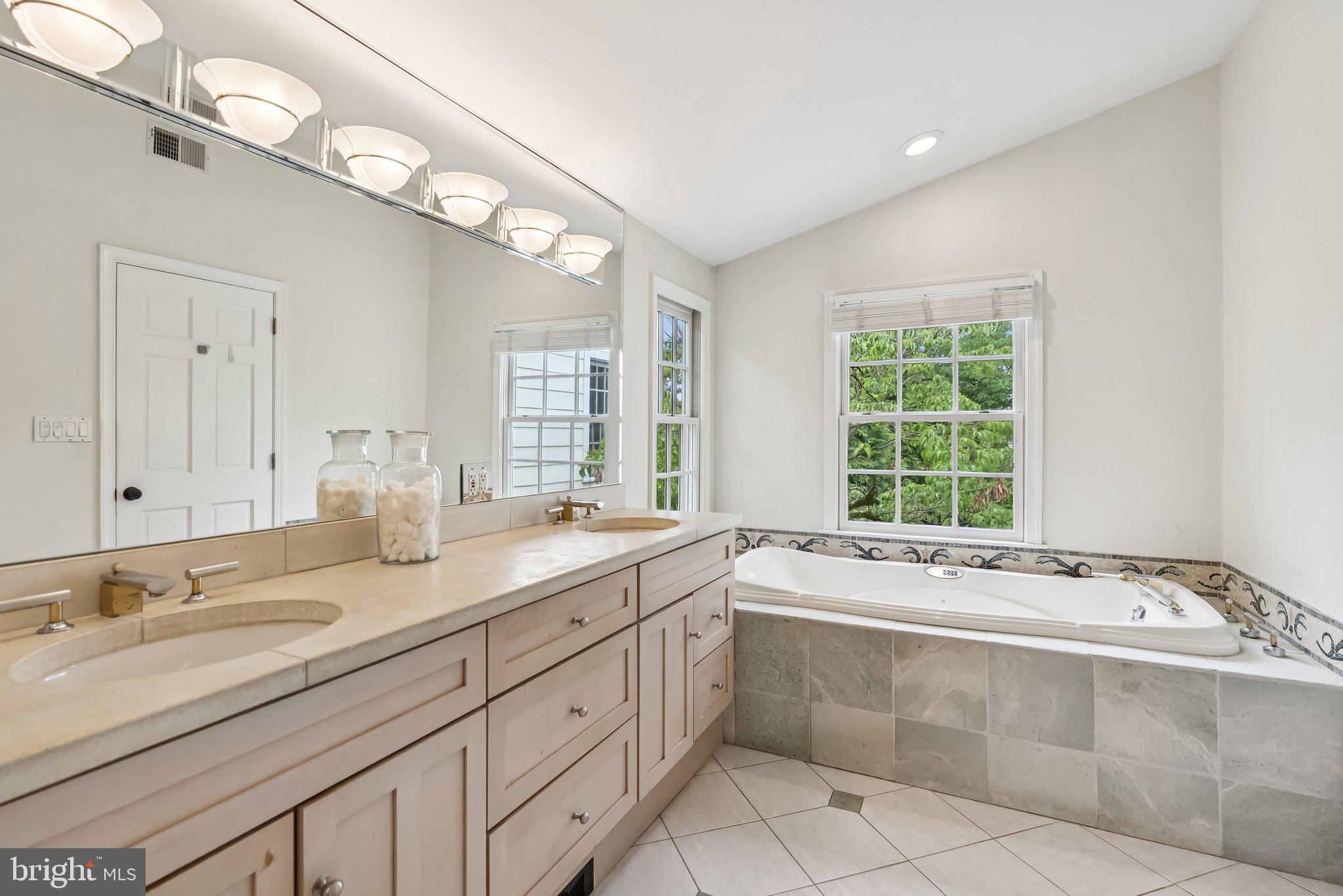 8109 Custer Road Bethesda, MD 20814 - Photo 25 of 54 a spacious bathroom with a granite countertop sink mirror and a bathtub