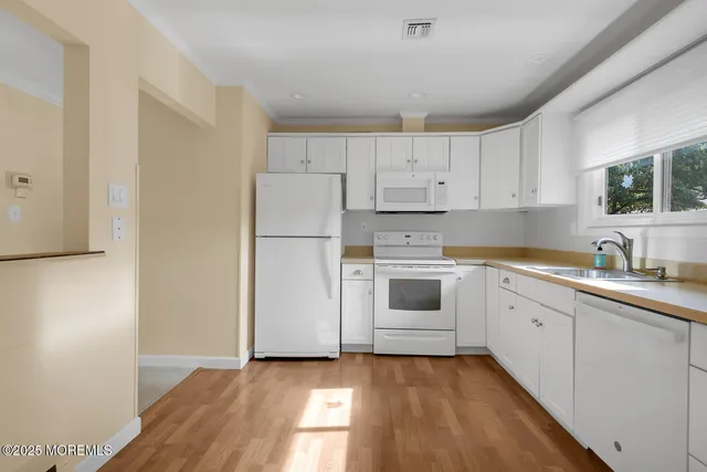 a kitchen with white cabinets and white appliances