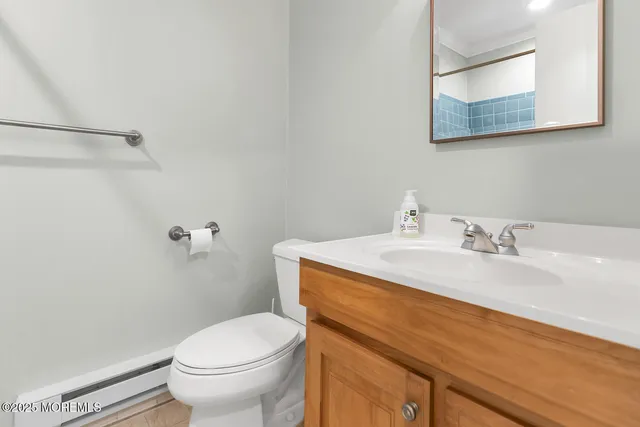 a bathroom with a granite countertop toilet sink and mirror