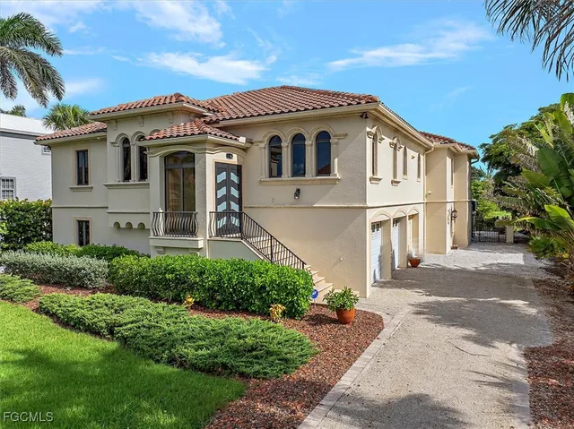 a view of a white house with a large windows and a yard