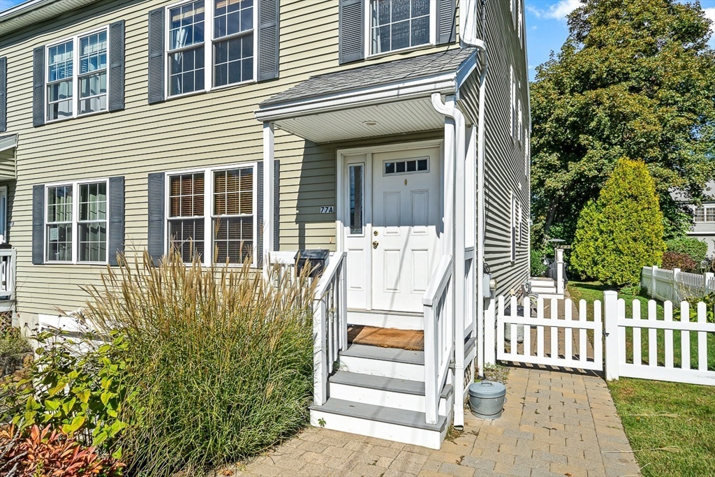 77 Warren Street, Unit A Arlington, MA 02474 - Photo 2 of 34 a view of a house with a small yard and wooden floor and fence