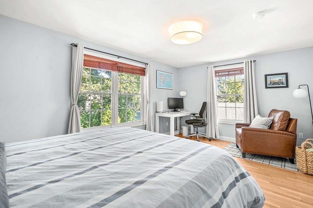 77 Warren Street, Unit A Arlington, MA 02474 - Photo 24 of 34 a bedroom with a bed and a couch