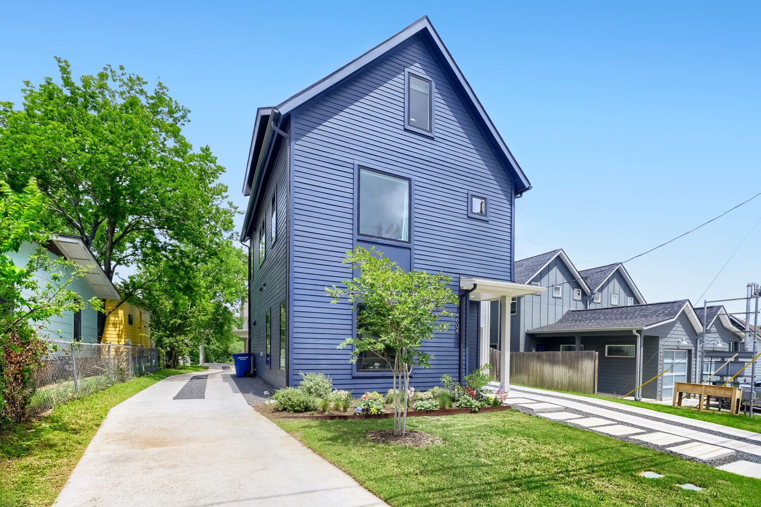 4804 Ribbecke Avenue, Unit A Austin, TX 78721 - Photo 32 of 32 The property features a dark blue exterior with horizontal siding and a prominent gable roof