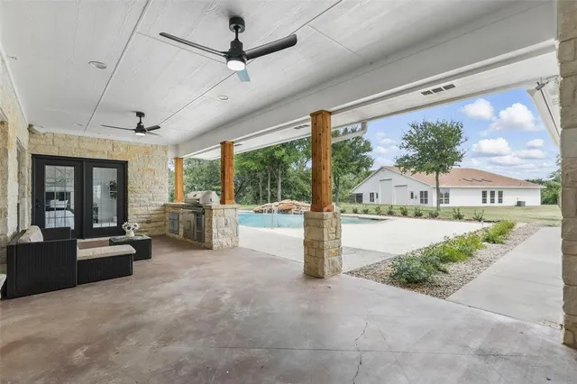 a large living room with stainless steel appliances kitchen island granite countertop furniture and a large window