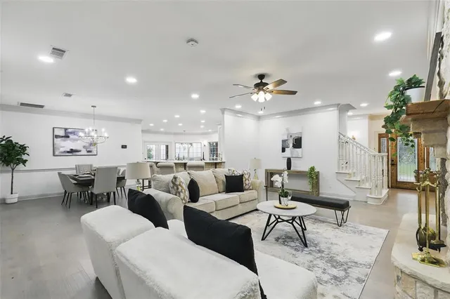 a living room with furniture kitchen view and a chandelier