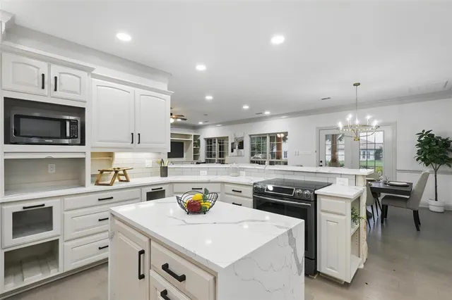 a kitchen with a sink a stove and chairs