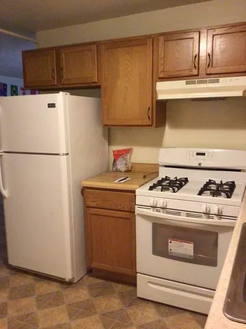 a white stove top oven sitting inside of a kitchen
