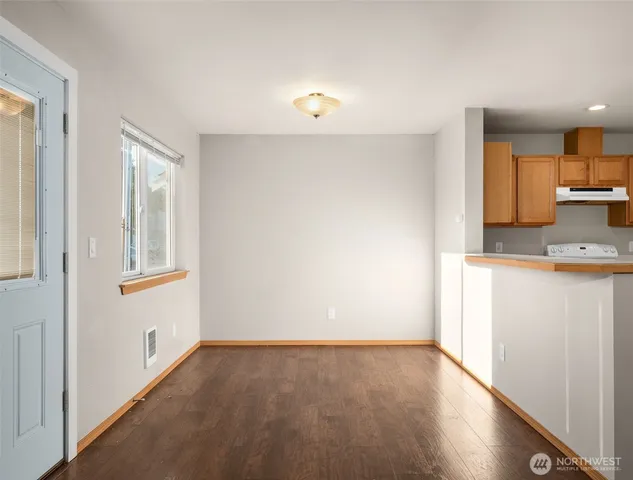 a view of a kitchen with a sink and dishwasher with wooden floor