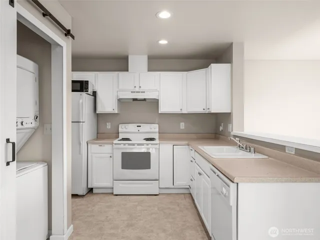 a kitchen with white cabinets and white appliances