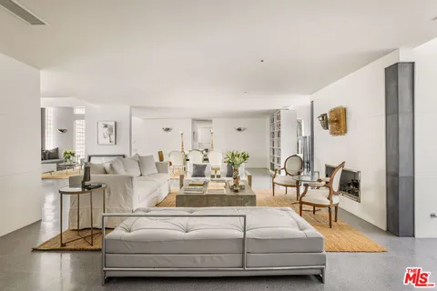 a living room with furniture a rug and white walls