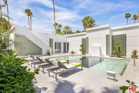 a view of a house with swimming pool and sitting area