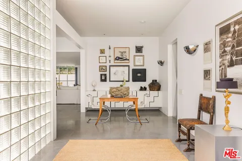 a living room with furniture a rug and white walls