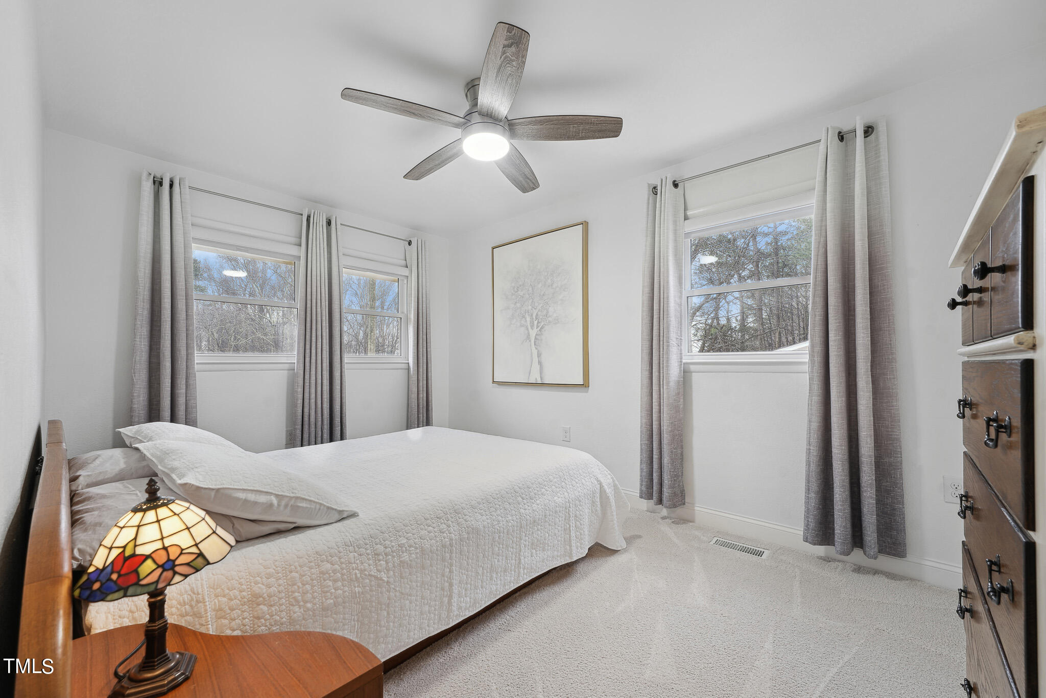 6320 Tryon Road Cary, NC 27518 - Photo 14 of 30 a bedroom with a bed and a chandelier