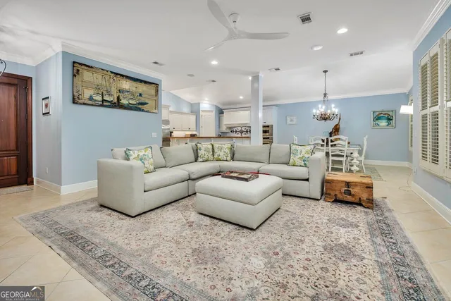 a living room with furniture and a dining table with wooden floor