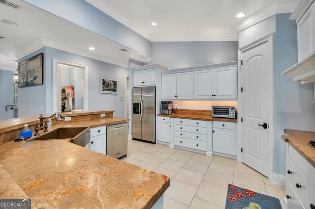 a kitchen with granite countertop white cabinets and stainless steel appliances