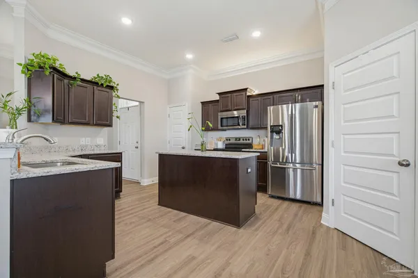 a kitchen with stainless steel appliances granite countertop a refrigerator stove and sink